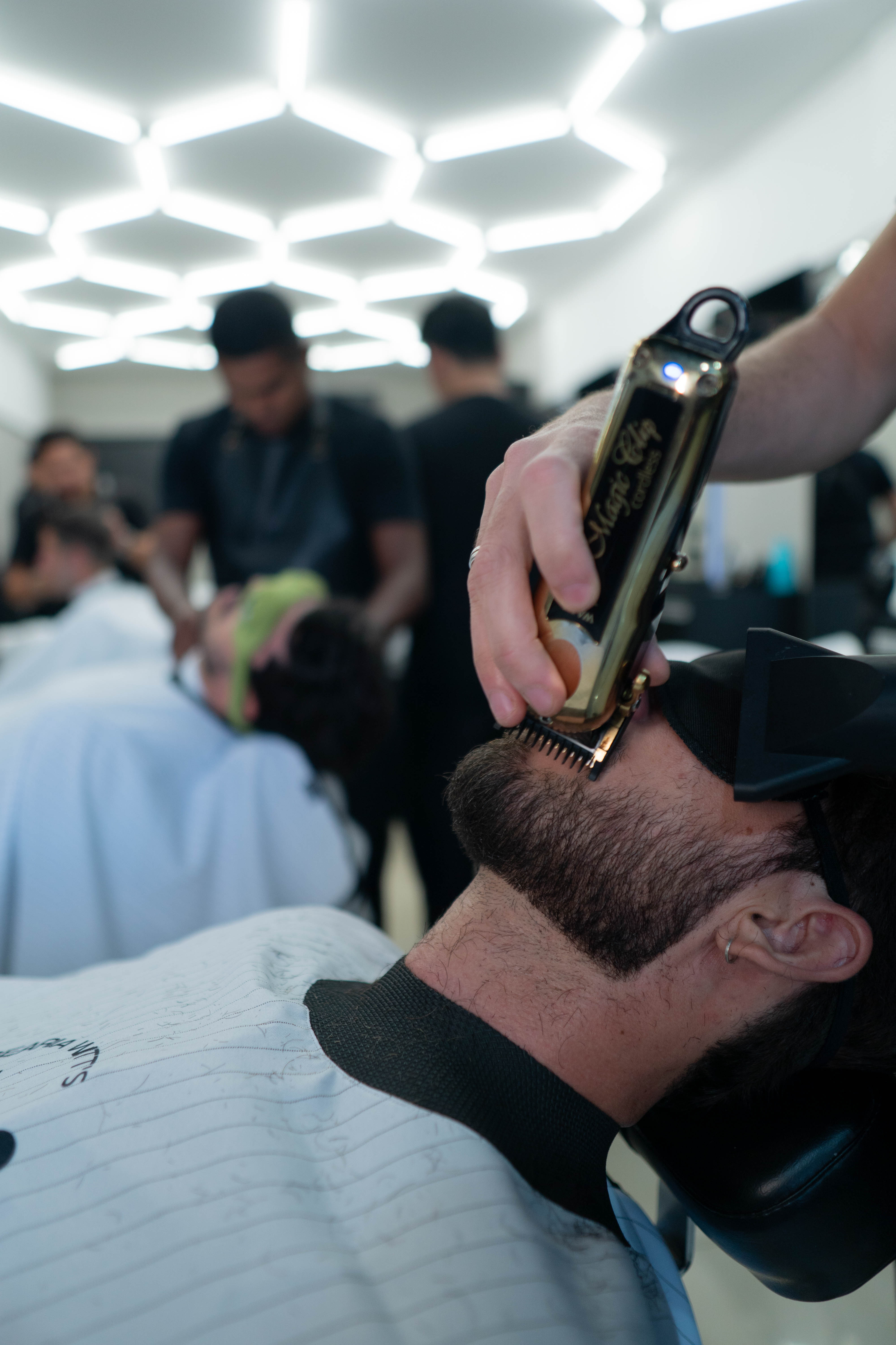 Barbeiro alinhando a barba com máquina